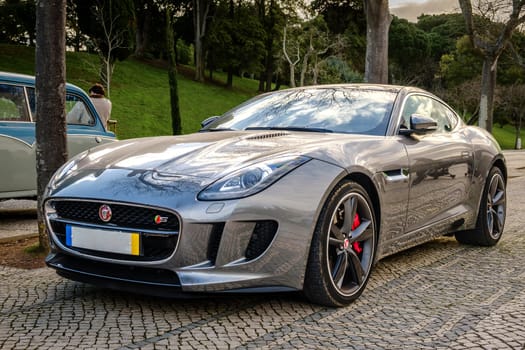 Lisbon, Portugal - Jan 20, 2024: Elegant Jaguar F-type coupe car parked on cobblestone pavement road. Two-seater two-door grand tourer class by Jaguar Land Rover manufacturer