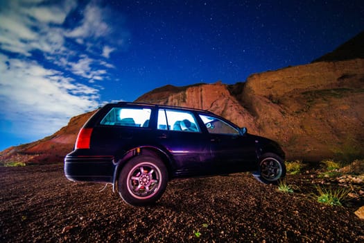 old black German station wagon car at starry summer night in the desert