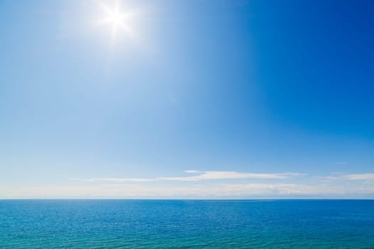 large open water surface with far snowcapped mountain range on the horizon at sunny day.