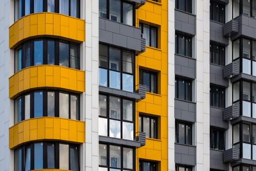 freshly built white-grey-yellow high rise apartment building, full-frame closeup.