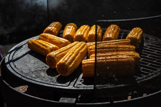 A professional cook prepares corn on the grill outdoor, food or catering concept