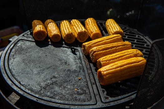 A professional cook prepares corn on the grill outdoor, food or catering concept