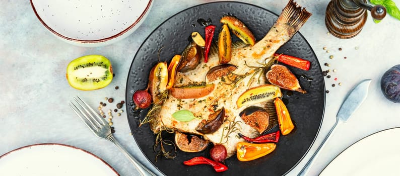 Whole flounder fish or plaice fish steamed with seasonal fruits and spices. Top view.