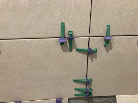 The process of laying tiles on the wall of a the room