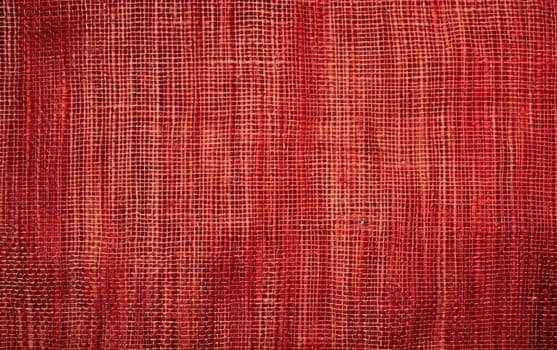 A close-up of crumpled red textile, highlighting texture and shadow for a dramatic and artistic background effect. Burlap fabric texture - background.