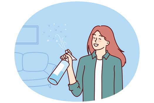 Woman uses air freshener to get rid of unpleasant smell in apartment after cleaning. Housewife girl stands in living room with air freshener spraying fragrance to create comfortable environment