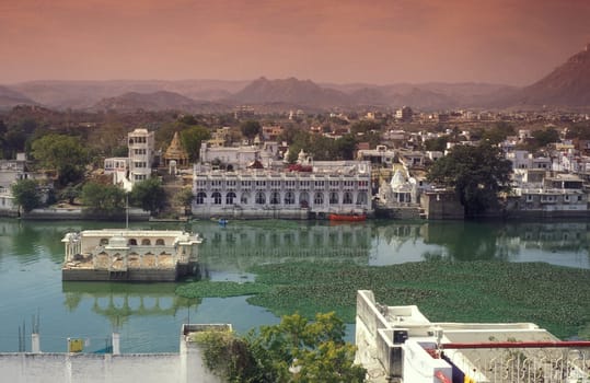 Architectur with Palace and Houses on the Pichhola Lake in the Town of Udaipur in the Province of Rajasthan in India.  India, Udaipur, January, 1998