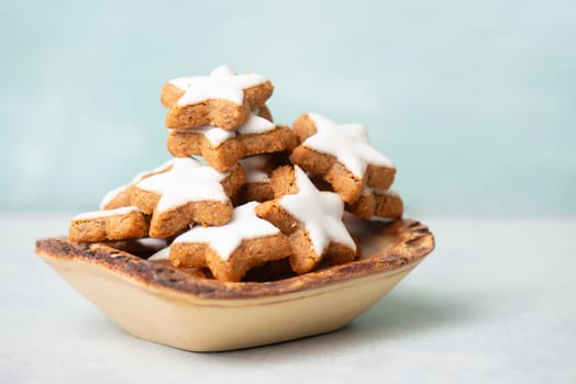 Cinnamon stars, Zimtsterne traditional german christmas cookies in a bowl, gingerbread with anise spice for holidays, fir branches