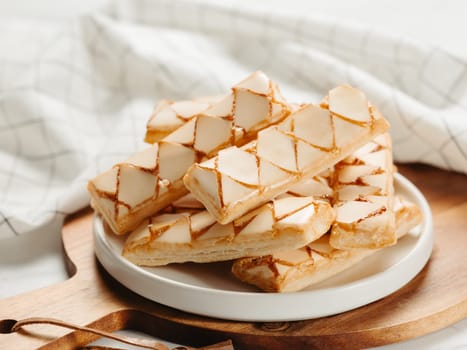 Italian crispy sweet bakery Sfogliatine glassate over white marble table surface. Tasty breakfast with apricot glaze puff pastries.