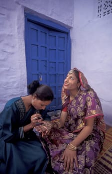 a Rajasthani women is making a Henna Hand painting in the Town of Jaisalmer in the Province of Rajasthan in India.  India, Jaisalmer, January, 1998
