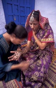 a Rajasthani women is making a Henna Hand painting in the Town of Jaisalmer in the Province of Rajasthan in India.  India, Jaisalmer, January, 1998