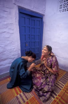 a Rajasthani women is making a Henna Hand painting in the Town of Jaisalmer in the Province of Rajasthan in India.  India, Jaisalmer, January, 1998