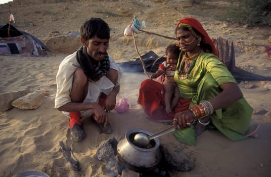 a Rajasthani Family is cocking on a fire with her Baby in the Town of Jaisalmer in the Province of Rajasthan in India.  India, Jaisalmer, January, 1998