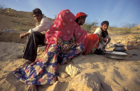 a Rajasthani women is cocking on a fire with her Baby in the Town of Jaisalmer in the Province of Rajasthan in India.  India, Jaisalmer, January, 1998