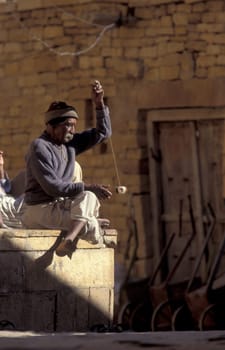 a men at spinning thread in alley in the Old Town of Jaisalmer in the Province of Rajasthan in India.  India, Jaisalmer, January, 1998