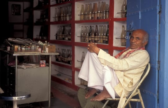 A Indian Doctor at his Drugstore and Madicine Shop at a market in the Town of Jaisalmer in the Province of Rajasthan in India.  India, Jaisalmer, January, 1998