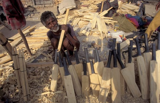 a men carving new wood cricket Bat at a Factory in the City of Jaisalmer in the Province of Rajasthan in India.  India, Jaisalmer, January, 1998