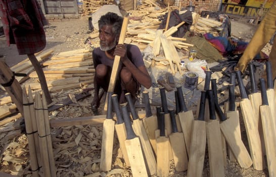 a men carving new wood cricket Bat at a Factory in the City of Jaisalmer in the Province of Rajasthan in India.  India, Jaisalmer, January, 1998