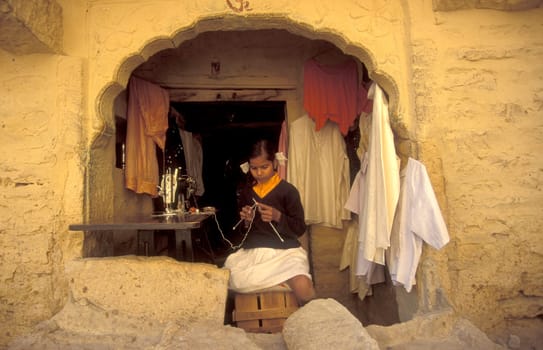 a young Rajasthani women at a Tailor shop in the Town of Jaisalmer in the Province of Rajasthan in India.  India, Jaisalmer, January, 1998