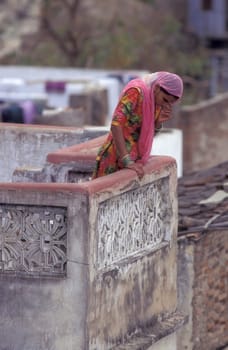 a Women stay at her Home and Balcony in the old Town at Jaisalmer Fort in city of Jaisalmer at  Province of Rajasthan in India.  India, Jaisalmer, January, 1998