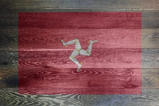 An Isle of man flag on rustic old wood surface background