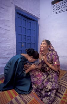 a Rajasthani women is making a Henna Hand painting in the Town of Jaisalmer in the Province of Rajasthan in India.  India, Jaisalmer, January, 1998