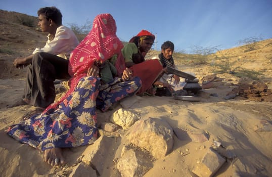 a Rajasthani women is cocking on a fire with her Baby in the Town of Jaisalmer in the Province of Rajasthan in India.  India, Jaisalmer, January, 1998