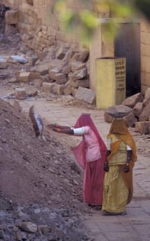 two Rajasthani women at a construction work in the Town of Jaisalmer in the Province of Rajasthan in India.  India, Jaisalmer, January, 1998