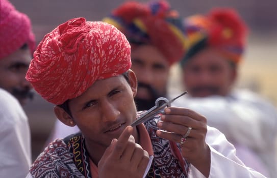 musicians in traditional Rajasthani dress at the Bikaner Camel Festival in the Town of Bikaner in the Province of Rajasthan in India.  India, Bikaner, January, 1998