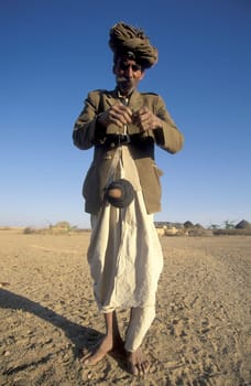 A old Men work with a Cord Spindle in a small Village near the Town of Bikaner in the Desert Thar in the Province of Rajasthan in India.  India, Bikaner, January, 1998