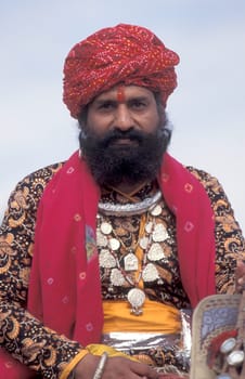 a camel herder in traditional Rajasthani dress at the Bikaner Camel Festival in the Town of Bikaner in the Province of Rajasthan in India.  India, Bikaner, January, 1998