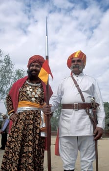 two camel herder in traditional Rajasthani dress at the Bikaner Camel Festival in the Town of Bikaner in the Province of Rajasthan in India.  India, Bikaner, January, 1998