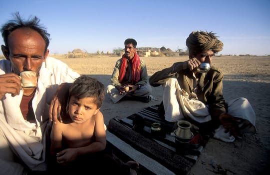 a Rajasthani Men drinks a Tea in a small Village near the Town of Bikaner in the Province of Rajasthan in India.  India, Bikaner, January, 1998