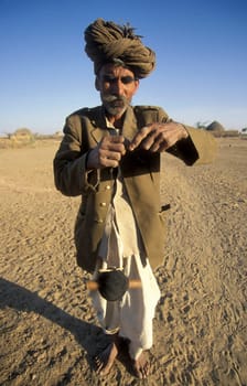 A old Men work with a Cord Spindle in a small Village near the Town of Bikaner in the Desert Thar in the Province of Rajasthan in India.  India, Bikaner, January, 1998