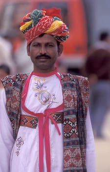 a camel herder in traditional Rajasthani dress at the Bikaner Camel Festival in the Town of Bikaner in the Province of Rajasthan in India.  India, Bikaner, January, 1998