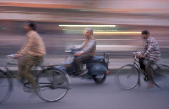 a Motorbike and bicycle traffic on a road in the City of Jaipur in the Province of Rajasthan in India.  India, Jaipur, January, 1998