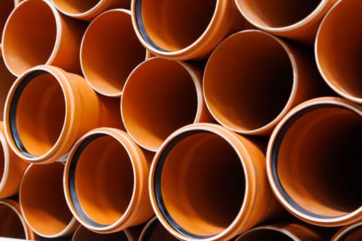 brown plastic plumbing pipes with rubber seals - full-frame closeup background