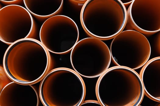 brown plastic plumbing pipes with rubber seals - full-frame closeup background
