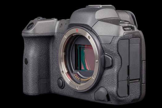 black 2020s professional 35mm full-frame mirrorless camera body with flip screen isolated on black background.
