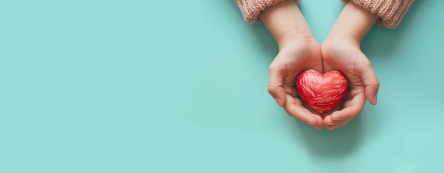 Hands holding a red heart, love and emotion concept, thank you, help and charity, christmas gift, valentine