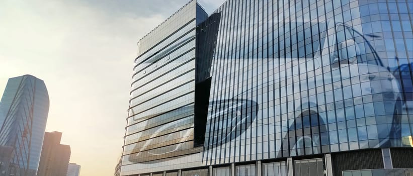 Corporate headquarters building for electric and hydrogen fuel cell car dealership in automotive industry. Modern glass architecture. Sustainable infrastructure. Corporate business environments.