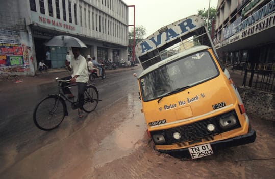 a car accident with a hole in the road by rain showers in the city centre of Mumbai in India.  India, Mumbai, March, 1998
