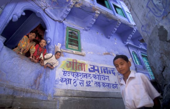 children at a blue painted living House in the Blue City and Town of Jodhpur in the Province of Rajasthan in India.  India, Jodhpur, January, 1998