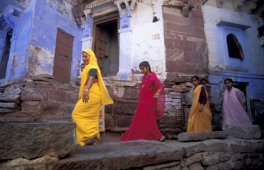 People in a alley with blue painted living House in the Blue City and Town of Jodhpur in the Province of Rajasthan in India.  India, Jodhpur, January, 1998