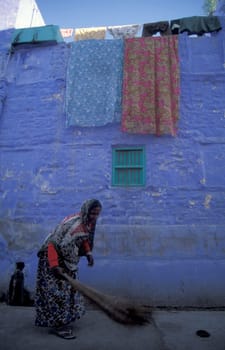 a women at a blue painted living House in the Blue City and Town of Jodhpur in the Province of Rajasthan in India.  India, Jodhpur, January, 1998