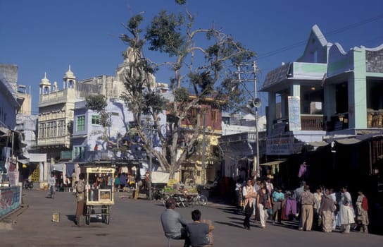 People at a square with blue painted living House in the Blue City and Town of Jodhpur in the Province of Rajasthan in India.  India, Jodhpur, January, 1998