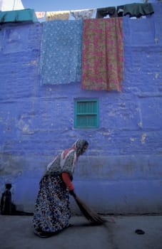 a women at a blue painted living House in the Blue City and Town of Jodhpur in the Province of Rajasthan in India.  India, Jodhpur, January, 1998