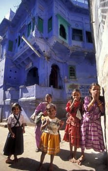children at a blue painted living House in the Blue City and Town of Jodhpur in the Province of Rajasthan in India.  India, Jodhpur, January, 1998