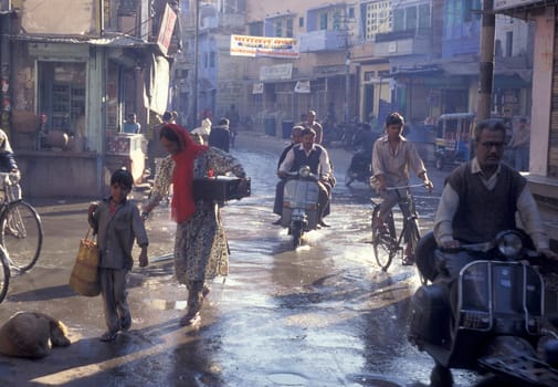 the Traffic with Motorbike and Bicycle in the Blue City and Town of Jodhpur in the Province of Rajasthan in India.  India, Jodhpur, January, 1998
