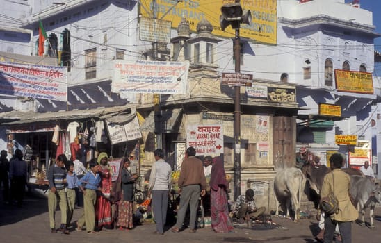 People at a square with blue painted living House in the Blue City and Town of Jodhpur in the Province of Rajasthan in India.  India, Jodhpur, January, 1998